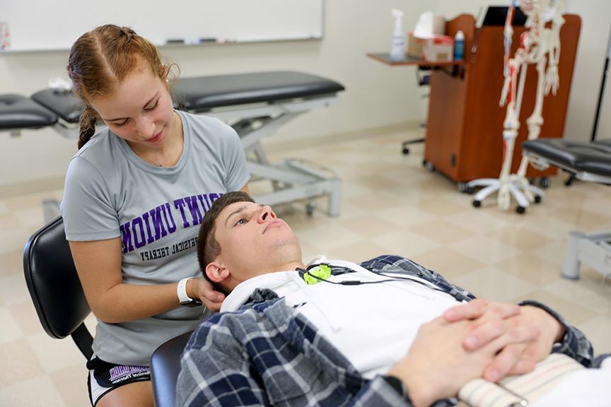 A DPT student engaging in hands-on learning during a classroom lab.